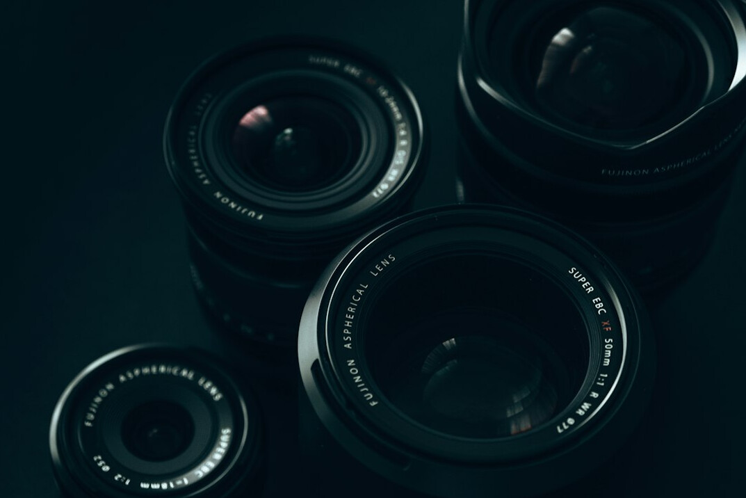 Paparazzi cameras with flash lights against a dark background